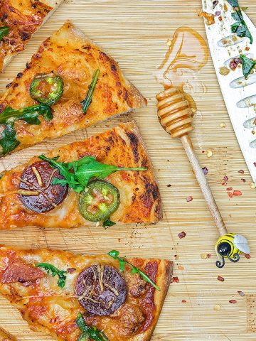 A simple, yet effortlessly stunning pepperoni pizza covered with handfuls of fresh arugula and drizzled with ribbons of chili-spiced hot honey.