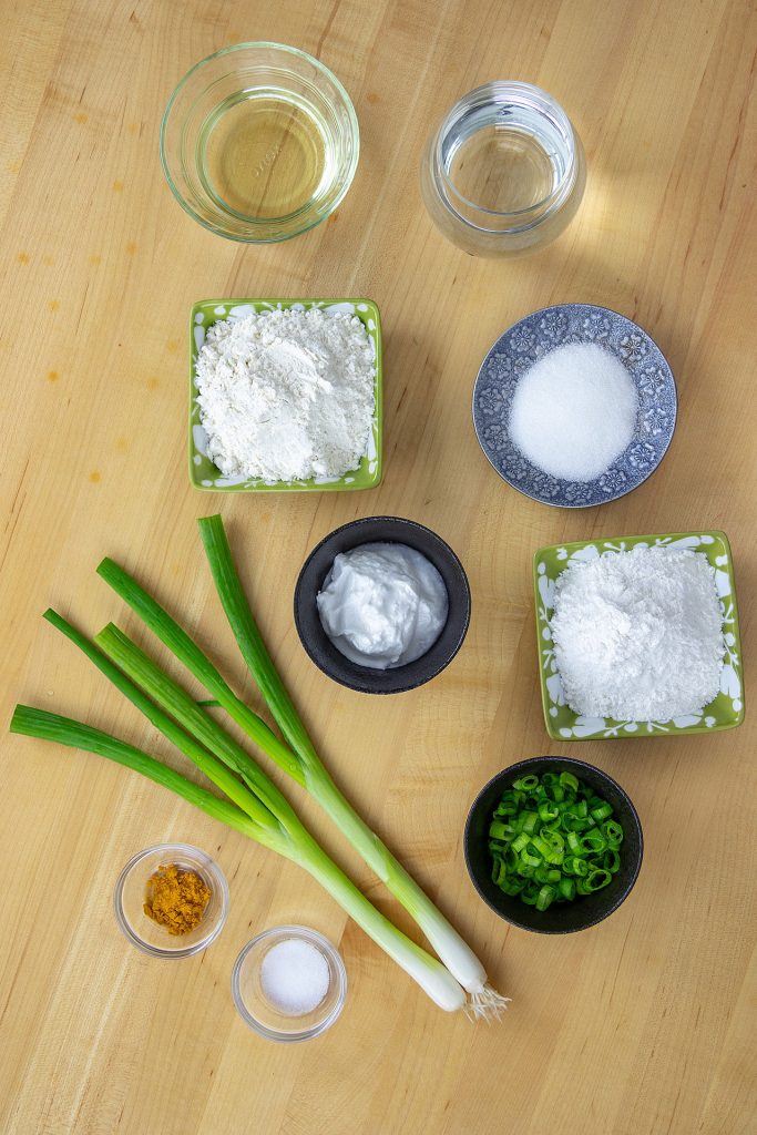 Ingredients for Banh Xeo Batter which includes all-purpose flour, rice flour, turmeric powder, salt, sugar, water, coconut milk, scallion and vegetable oil 