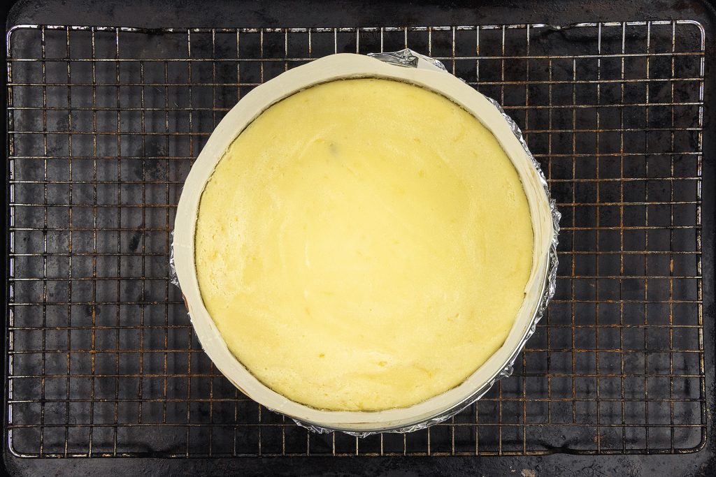 The baked cheesecake cooling on a wire rack