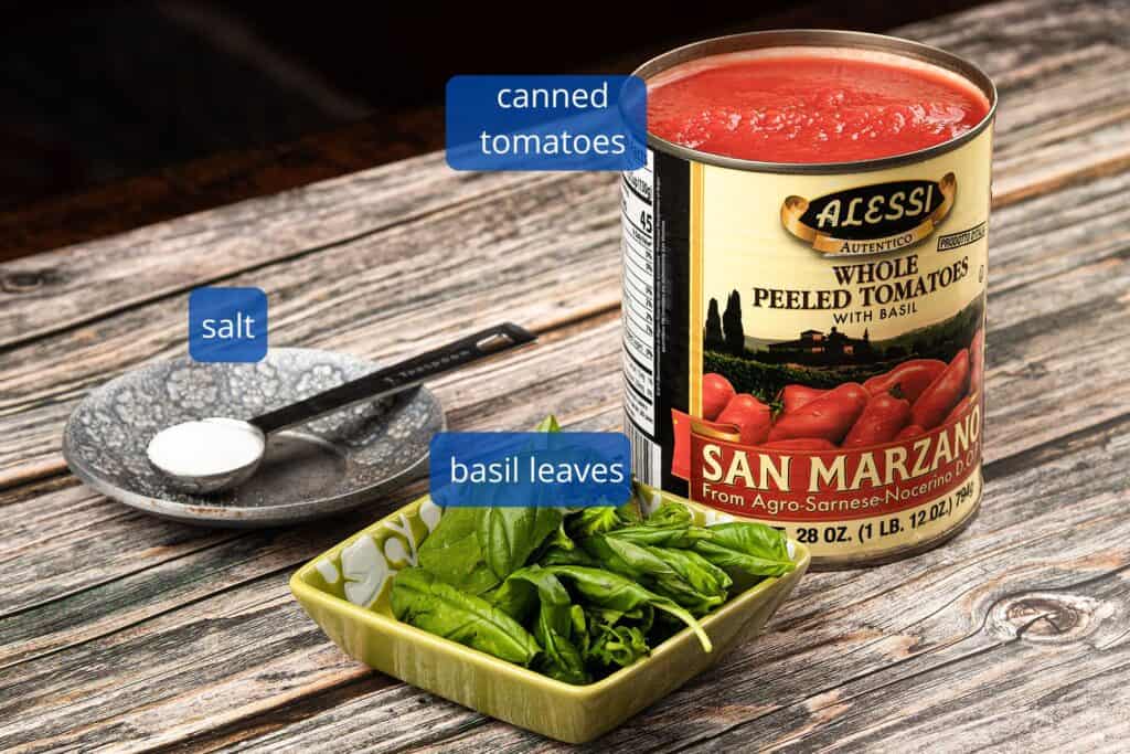 Ingredients for pizza sauce with canned tomatoes which includes canned tomatoes from San Marzano, salt and fresh basil leaves (optional)
