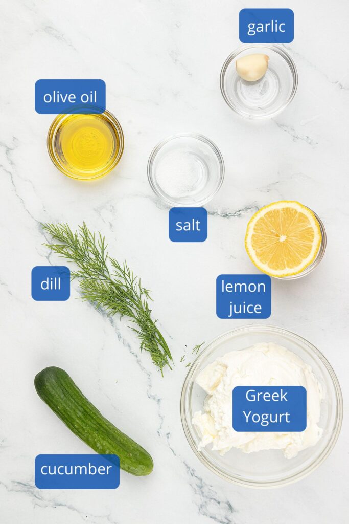 Ingredients for Tzatziki Sauce which includes garlic, lemon juice, Greek uogurt, cucumber, dill, salt and olive oil.